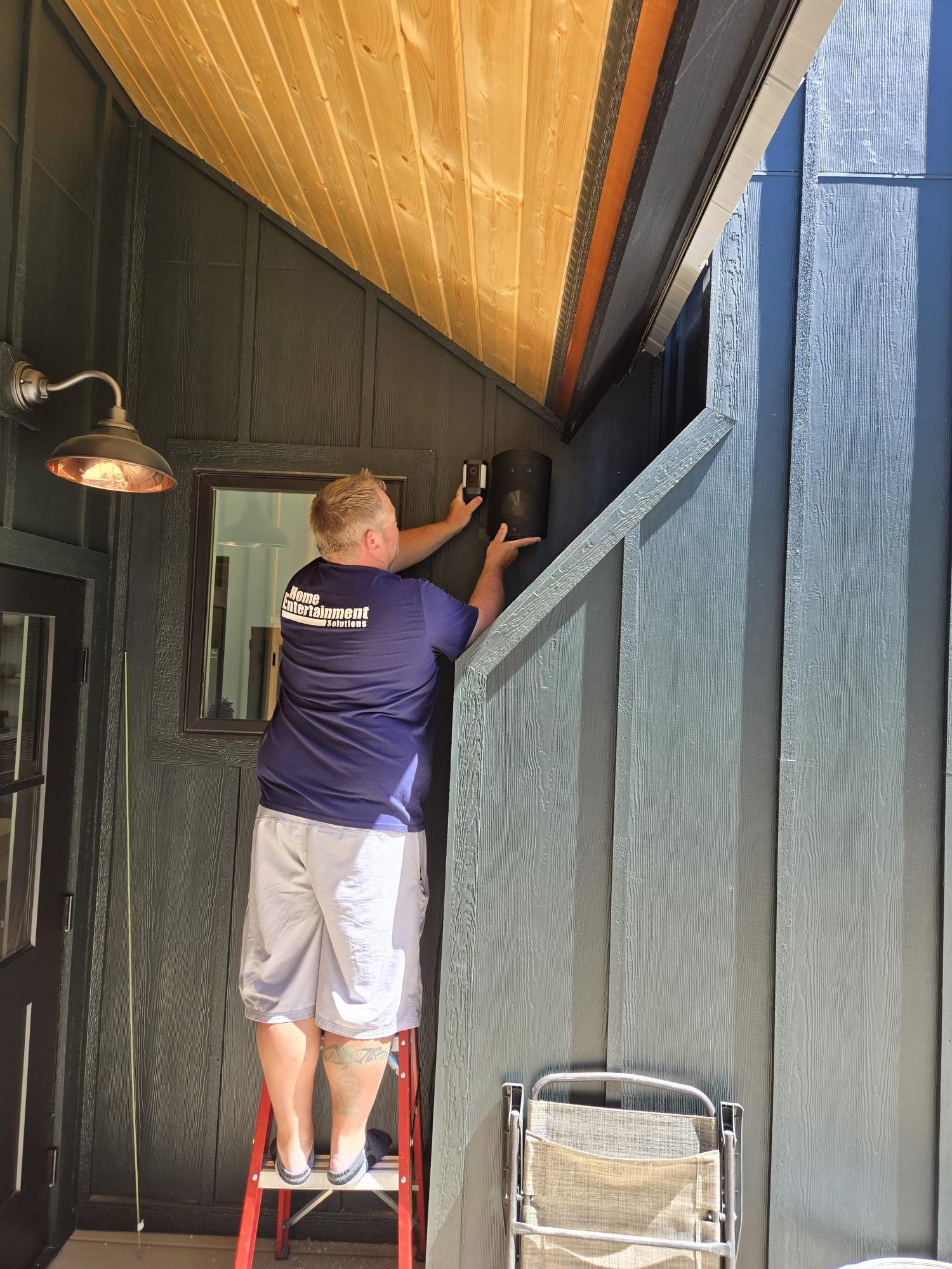 HES installer positioning a porch speaker in Leavenworth